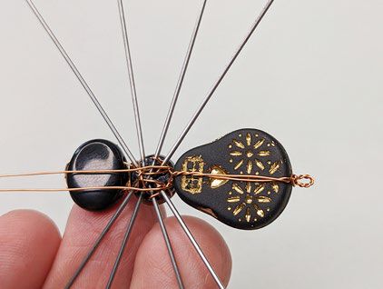 Ends of wire are secured by winding them around the legs on the underside of the spider.